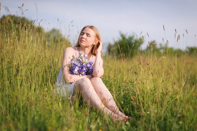 Photo of Beautiful woman with bouquet of wildflowers enjoying sunny day in meadow