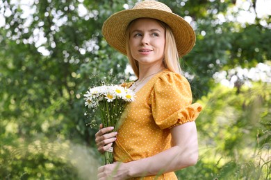 Photo of Beautiful woman with bouquet of wildflowers in forest