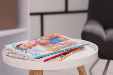 Photo of Different trendy magazines on white table indoors, closeup