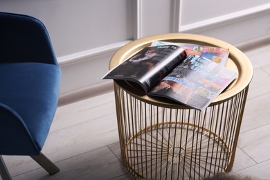 Photo of Different trendy magazines on table at home