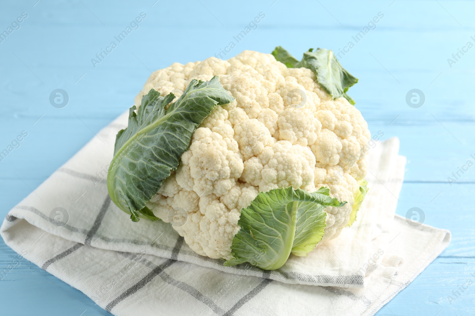 Whole cauliflower on light blue wooden table, closeup Photo of Whole cauliflower on light blue wooden table, closeup