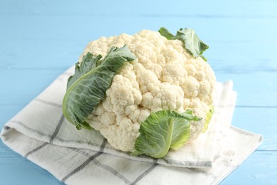 Photo of Whole cauliflower on light blue wooden table, closeup