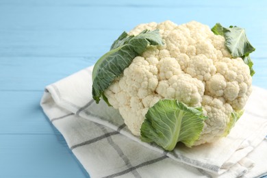 Photo of Whole cauliflower on light blue wooden table, closeup