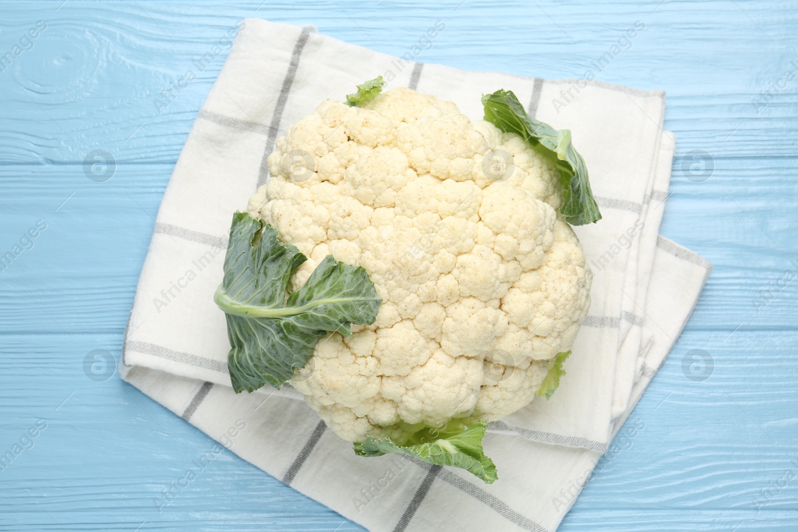 Whole cauliflower on light blue wooden table, top view Photo of Whole cauliflower on light blue wooden table, top view