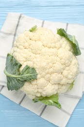 Photo of Whole cauliflower on light blue wooden table, top view