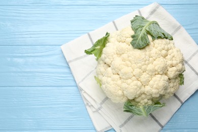 Photo of Whole cauliflower on light blue wooden table, top view. Space for text