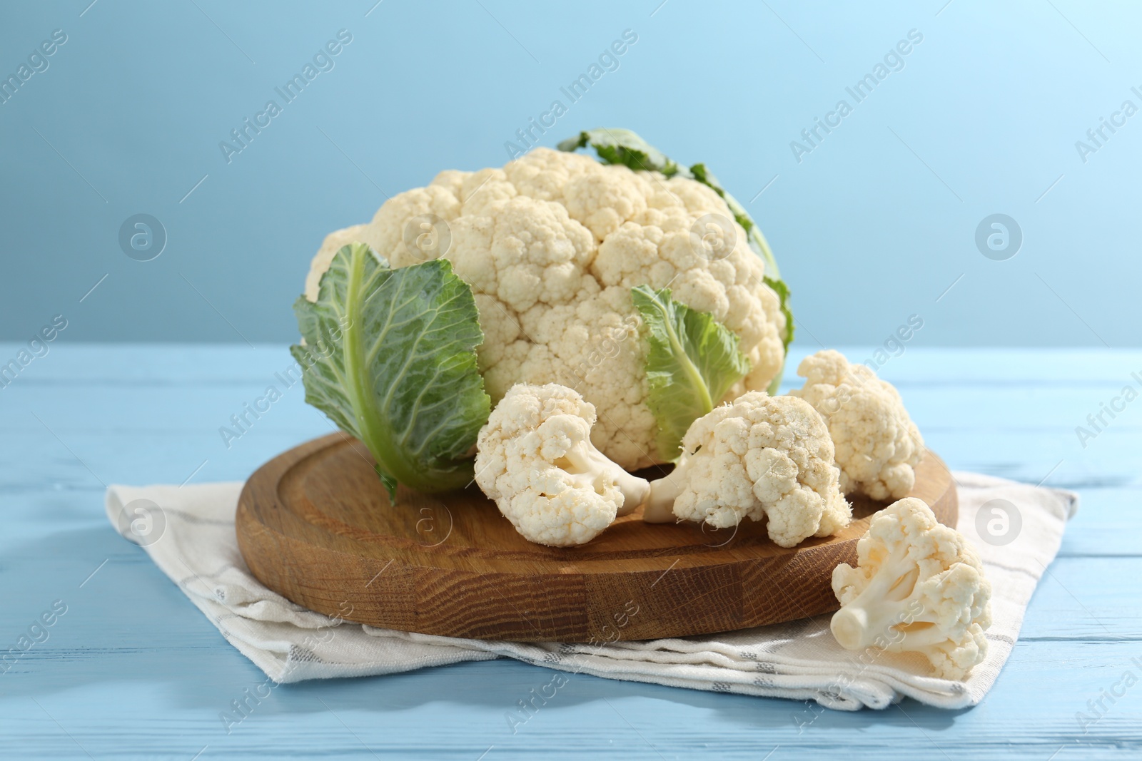 Raw cauliflower on light blue wooden table Photo of Raw cauliflower on light blue wooden table