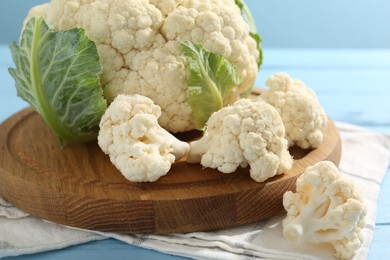 Photo of Raw cauliflower on light blue wooden table, closeup