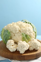 Photo of Raw cauliflower on light blue wooden table, closeup