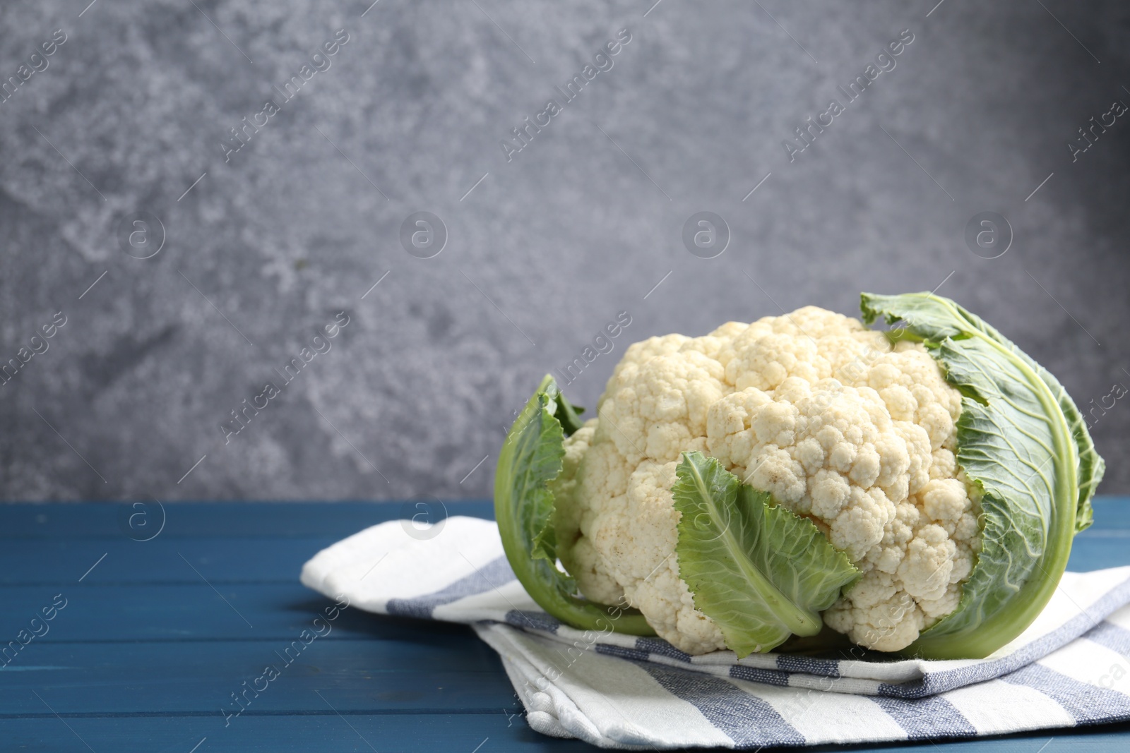 Whole raw cauliflower on blue wooden table. Space for text Photo of Whole raw cauliflower on blue wooden table. Space for text