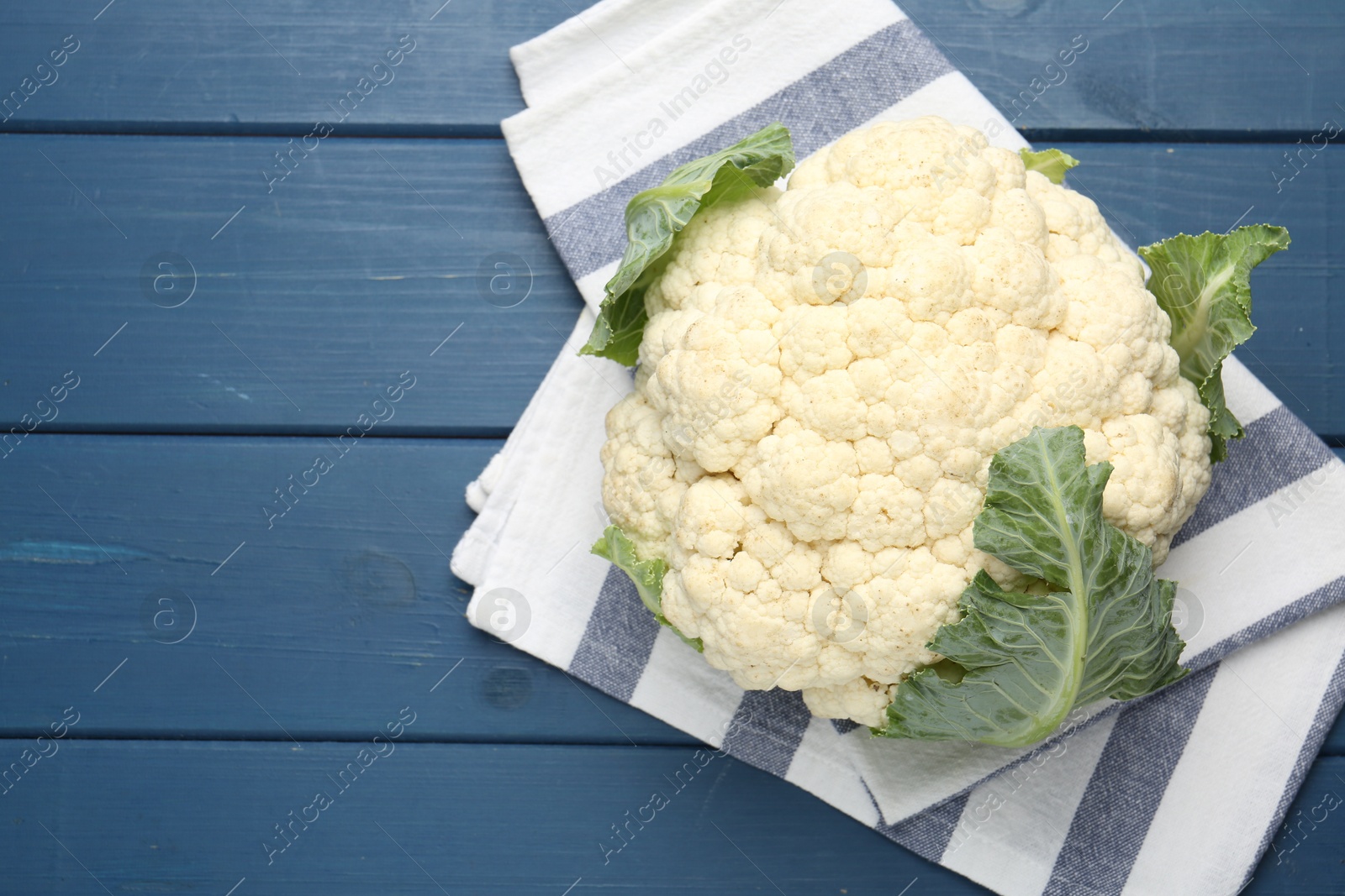 Whole cauliflower on blue wooden table, top view. Space for text Photo of Whole cauliflower on blue wooden table, top view. Space for text