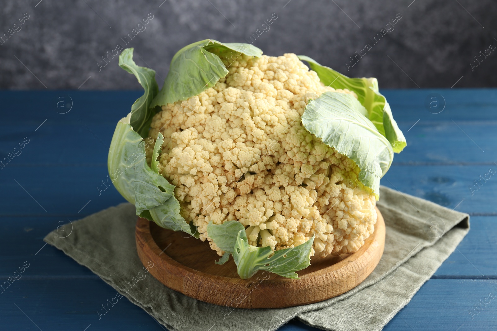 Whole cauliflower on blue wooden table, closeup Photo of Whole cauliflower on blue wooden table, closeup