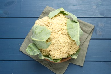 Photo of Whole cauliflower on blue wooden table, top view