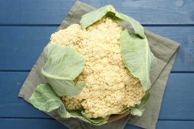 Photo of Whole cauliflower on blue wooden table, top view