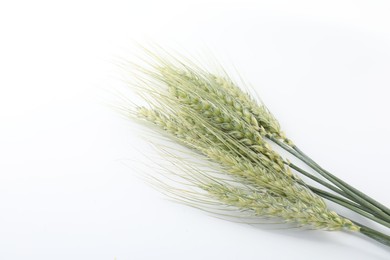 Photo of Many green wheat spikes on white background