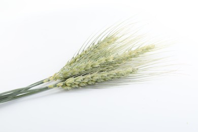 Photo of Many green wheat spikes on white background