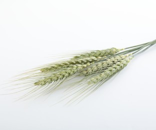 Photo of Many green wheat spikes on white background