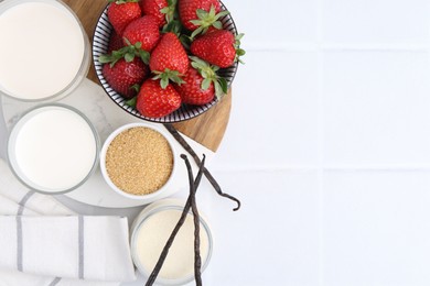 Photo of Different ingredients for panna cotta. Milk, sugar, vanilla and strawberries on white tiled table, flat lay. Space for text