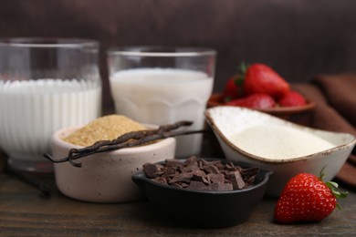 Photo of Different ingredients for panna cotta. Milk, sugar, vanilla, chocolate and strawberries on wooden table, closeup