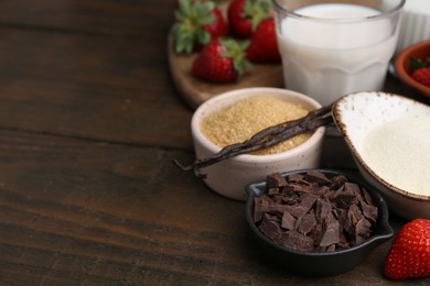 Photo of Different ingredients for panna cotta. Milk, sugar, vanilla, chocolate and strawberries on wooden table, closeup. Space for text