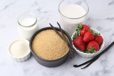 Photo of Different ingredients for panna cotta. Milk, sugar, vanilla and strawberries on white marble table, closeup