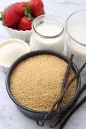 Photo of Different ingredients for panna cotta. Milk, sugar, vanilla and strawberries on white marble table, closeup