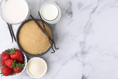 Photo of Different ingredients for panna cotta. Milk, sugar, vanilla and strawberries on white marble table, flat lay. Space for text