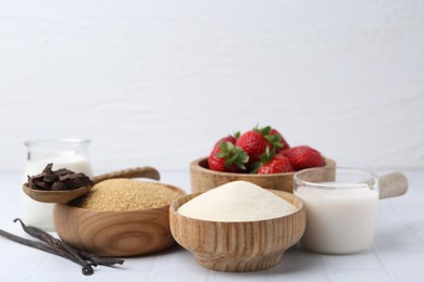 Photo of Different ingredients for panna cotta. Milk, sugar, vanilla, chocolate and strawberries on white tiled table, closeup