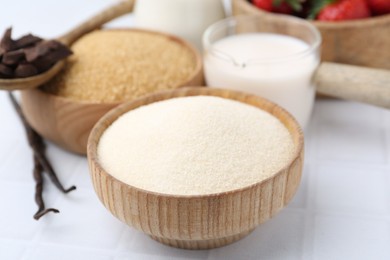 Photo of Different ingredients for panna cotta. Milk, sugar, vanilla, chocolate and strawberries on white tiled table, closeup