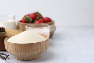 Photo of Different ingredients for panna cotta. Milk, sugar, vanilla, chocolate and strawberries on white tiled table, closeup. Space for text