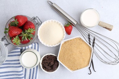 Photo of Different ingredients for panna cotta. Milk, sugar, vanilla, chocolate and strawberries on white table, flat lay