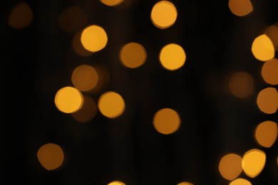 Photo of Blurred view of yellow lights on dark background, bokeh effect