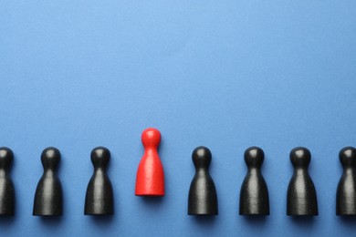 Photo of Unemployment. One red figure among black on blue background, flat lay. Space for text