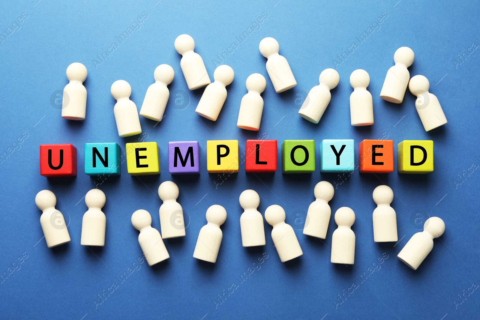 Photo of Word Unemployed and human figures on blue background, flat lay