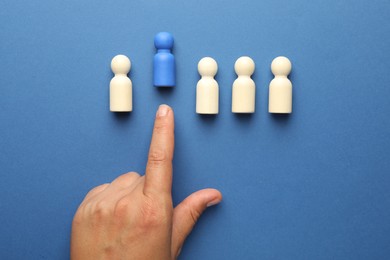 Photo of Dismissal. Woman throwing human figure away on blue background, top view