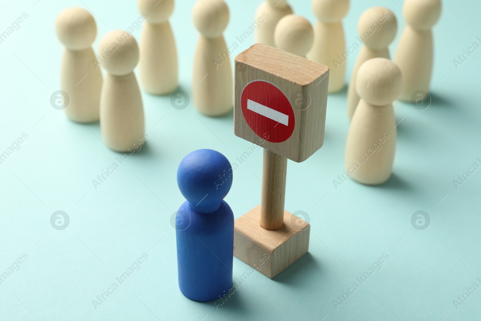 Unemployment. Human figures and stop sign on light blue background, closeup Photo of Unemployment. Human figures and stop sign on light blue background, closeup