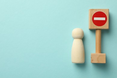 Photo of Unemployment. Human figure and stop sign on light blue background, top view. Space for text