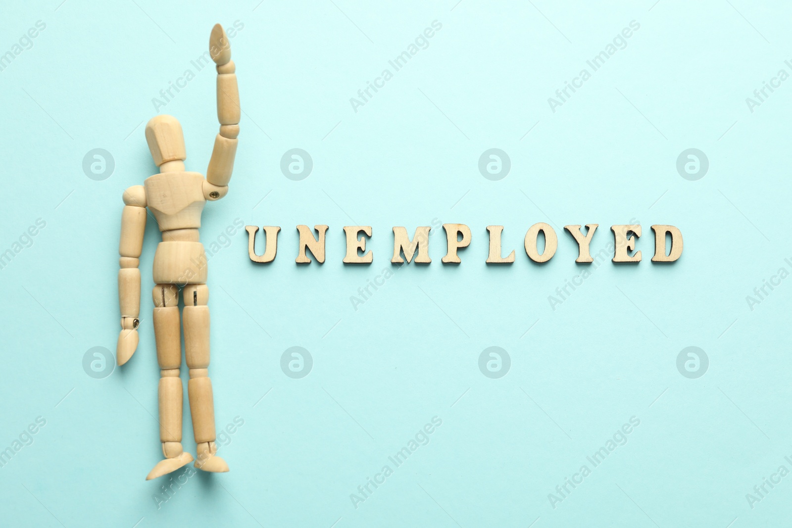 Word Unemployed and human figure on light blue background, flat lay Photo of Word Unemployed and human figure on light blue background, flat lay
