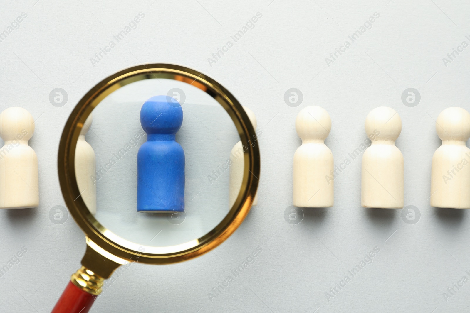 Unemployment. Human figures and magnifying glass on light background, flat lay Photo of Unemployment. Human figures and magnifying glass on light background, flat lay