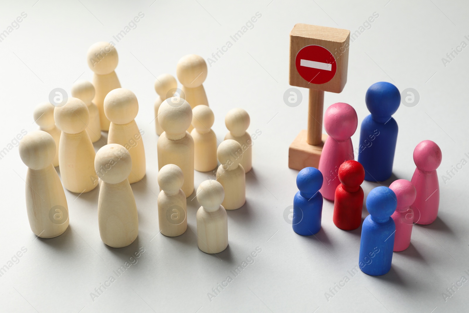 Photo of Unemployment. Many different human figures and stop sign on light background, closeup