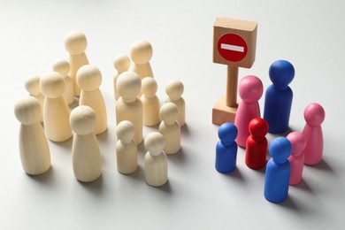 Photo of Unemployment. Many different human figures and stop sign on light background, closeup