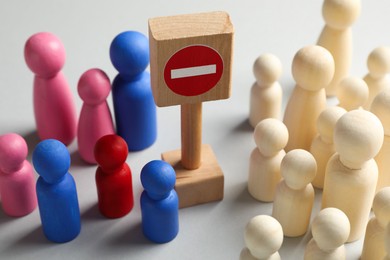 Photo of Unemployment. Many different human figures and stop sign on light background, closeup