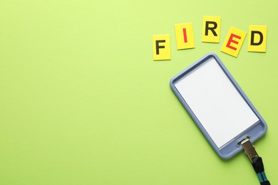 Photo of Dismissal. Word fired and badge on green background, top view. Space for text