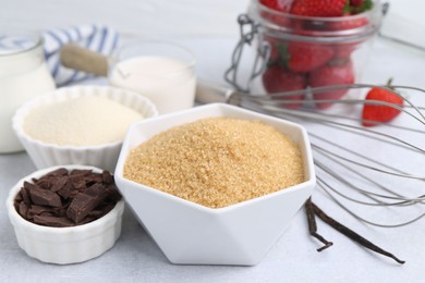 Photo of Different ingredients for panna cotta. Milk, sugar, vanilla, chocolate and strawberries on white table, closeup