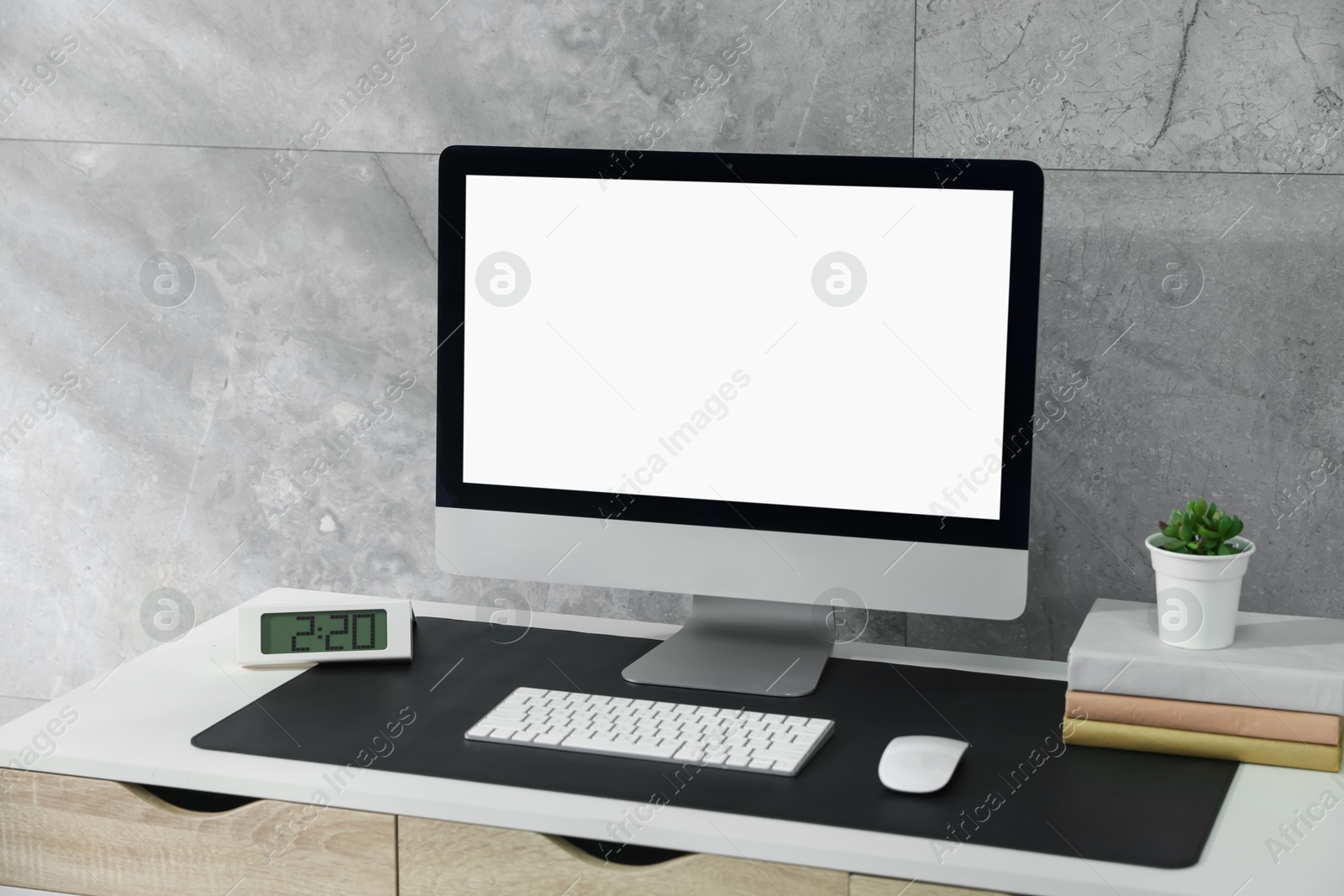 Photo of Stylish workplace with computer and black mousepad on white table indoors. Space for text