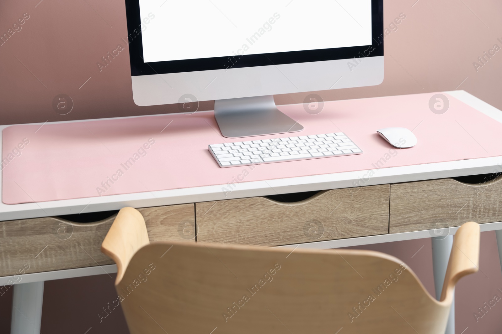 Stylish workplace with computer and pink mousepad on white table indoors. Space for text Photo of Stylish workplace with computer and pink mousepad on white table indoors. Space for text