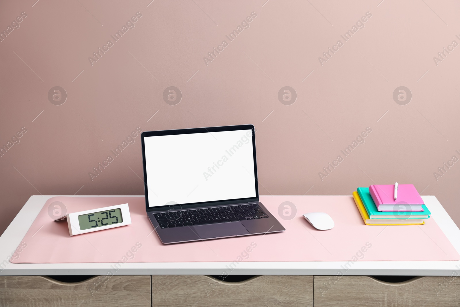 Stylish workplace with laptop and pink mousepad on white table indoors. Space for text Photo of Stylish workplace with laptop and pink mousepad on white table indoors. Space for text