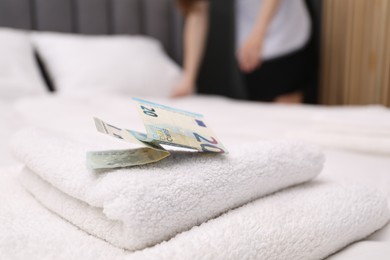 Photo of Tips and towels on bed in hotel room, closeup. Gratuity for work