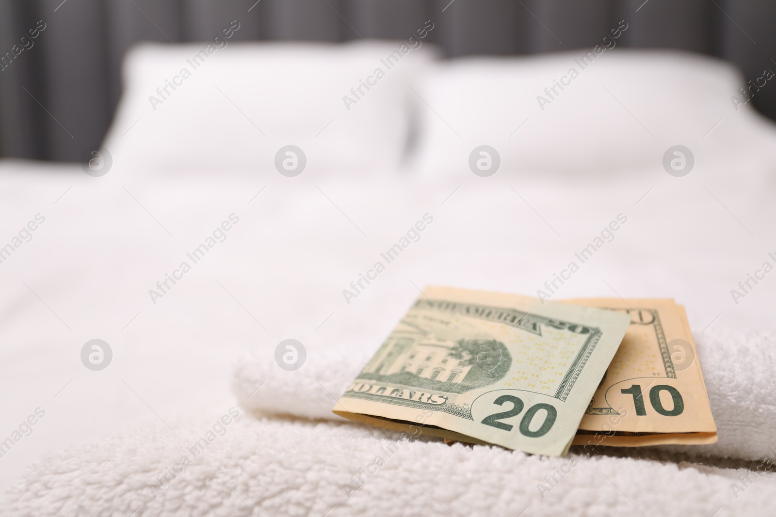 Photo of Tips and towels on bed in hotel room, closeup. Gratuity for work