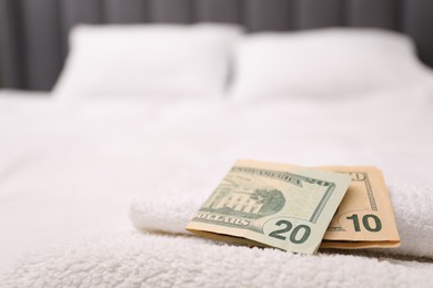 Photo of Tips and towels on bed in hotel room, closeup. Gratuity for work
